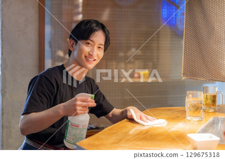 居酒屋:女店員為顧客提供飲料 居酒屋:女店員為顧客提供飲料 129675318