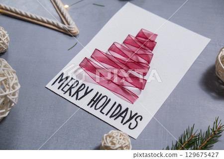 Christmas tree ribbon Gift Christmas idea. Do it yourself instruction postcard eco-friendly decoration. Making handmade presents children's diy projects. Holiday family time Christmas tree ribbon Gift Christmas idea. Do it yourself instruction postcard eco-friendly decoration. Making handmade presents children's diy projects. Holiday family time 129675427