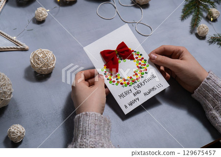 Christmas wreath Storytelling of creating craft Christmas greeting card holiday present. Tactile hand-on activity. Master class progress of creative me-made gifts. Seasonal domestic life micro moment 129675457