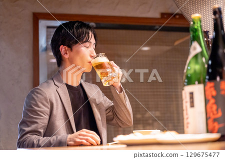 Izakaya: A man enjoying a drink alone Izakaya: A man enjoying a drink alone 129675477