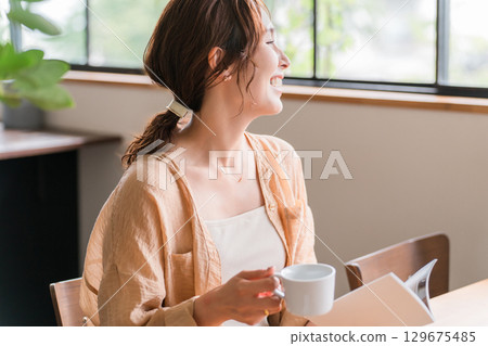 在咖啡館喝咖啡看書的女人 在咖啡館喝咖啡看書的女人 129675485