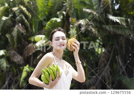 Woman with pineapple and banana 129675556
