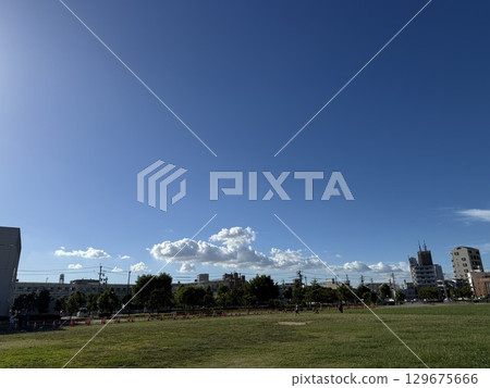 夏天蔚藍的天空和寬闊的草坪的公園景觀、白雲飄飄的晴朗天空和住宅區、以及被清爽的晴空籠罩的城市的天空和綠色植物。 夏天蔚藍的天空和寬闊的草坪的公園景觀、白雲飄飄的晴朗天空和住宅區、以及被清爽的晴空籠罩的城市的天空和綠色植物。 129675666