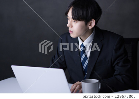 Young businessman working on a computer 129675803