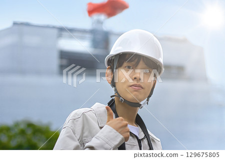 穿著工作服的年輕商人在建築工地上看著平板電腦 129675805