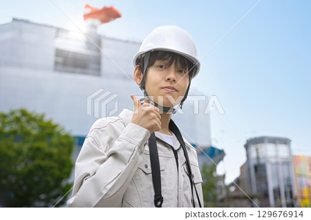 Young businessman in work clothes looking at a tablet at a construction site 129676914