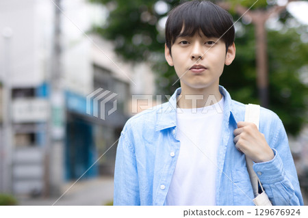 Portrait of a young man walking in the city Portrait of a young man walking in the city 129676924
