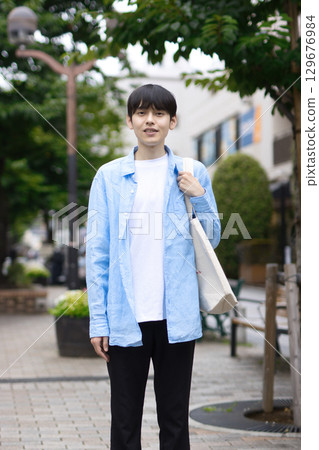 Portrait of a young man walking in the city Portrait of a young man walking in the city 129676984