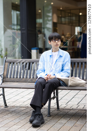 坐在城市長椅上的年輕人 129677410