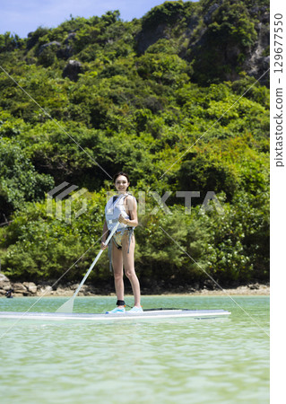 Cute woman enjoying SUP Cute woman enjoying SUP 129677550