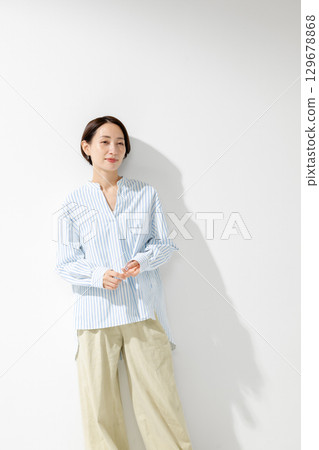 Middle-aged woman wearing a white shirt Middle-aged woman wearing a white shirt 129678868