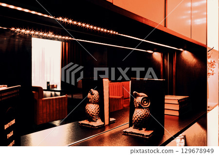 Decorative shelving and lounge bar interior through reflection in the mirror, blur stylization. Decorative shelving and lounge bar interior through reflection in the mirror, blur stylization. 129678949