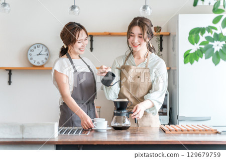 女咖啡師/烘焙師/在咖啡館/咖啡廳/咖啡店沖泡咖啡的師傅 女咖啡師/烘焙師/在咖啡館/咖啡廳/咖啡店沖泡咖啡的師傅 129679759