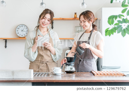 一名女教練和一名女學生在咖啡班/咖啡學校教授如何沖泡咖啡 一名女教練和一名女學生在咖啡班/咖啡學校教授如何沖泡咖啡 129679762