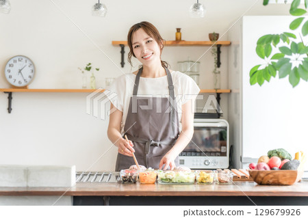 年輕的亞洲女性在廚房做飯（烹飪/家庭烹飪） 129679926