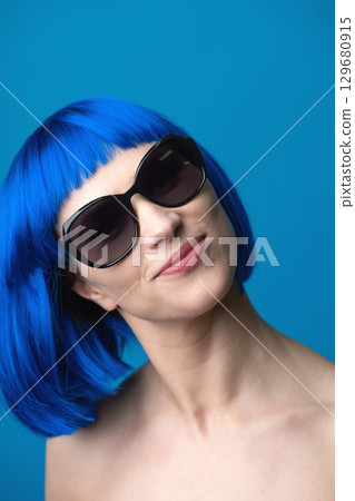 Close up beautiful woman with blue wig and sunglasses portrait 129680915