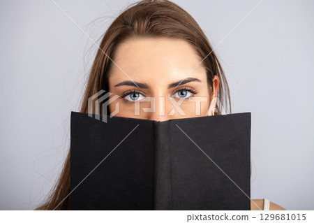 Portrait of beautiful woman reading book 129681015