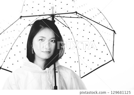 Asian woman with raincoat and transparent umbrella Asian woman with raincoat and transparent umbrella 129681125