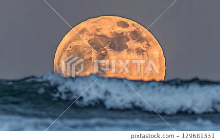 Golden Moon Rising Above a Turbulent Ocean 129681331