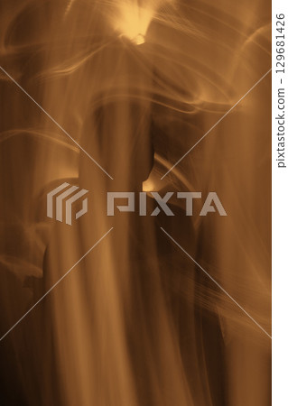Abstract human silhouette in light trails of light painting Abstract human silhouette in light trails of light painting 129681426