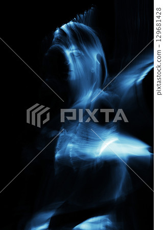 Light trails of light painting blue vivid color woman portrait 129681428