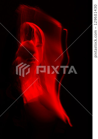 Light trails of light painting red vivid color woman portrait 129681430