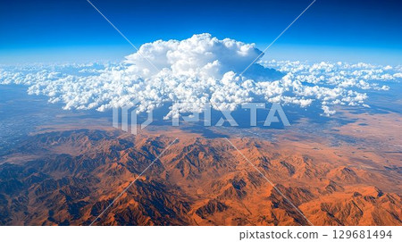 Aerial View of Immense Cumulus Cloud Over Desert Mountains 129681494