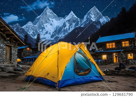 Illuminated Tent Under Starry Sky with Jagged Mountain Peaks in 129681790