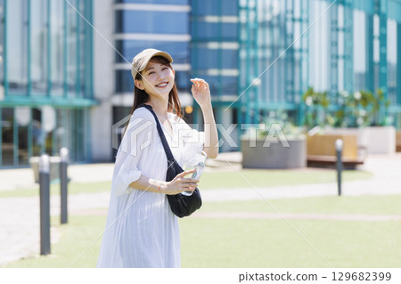 一位戴著帽子在戶外補水的女士 129682399