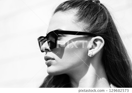 Beautiful woman with long dark hair and sunglasses outdoor close-up portrait Beautiful woman with long dark hair and sunglasses outdoor close-up portrait 129682573