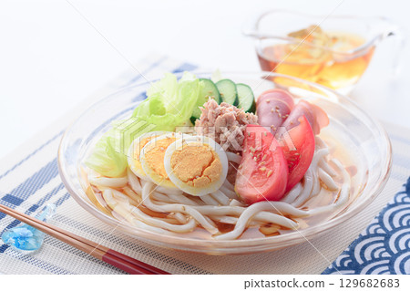 Perfect for summer, this refreshing glass bowl of salad udon is a colorful cold noodle dish with vegetables, eggs, and ham. 129682683