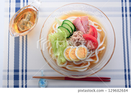 Perfect for summer, this refreshing glass bowl of salad udon is a colorful cold noodle dish with vegetables, eggs, and ham. 129682684