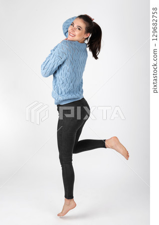 Beautiful woman portrait with blue sweater and black jeans Beautiful woman portrait with blue sweater and black jeans 129682758