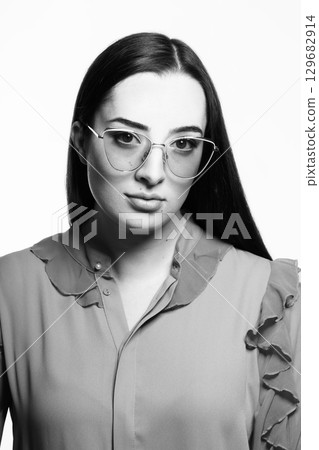 Beautiful woman with long dark hair and sunglasses black and white studio portrait 129682914