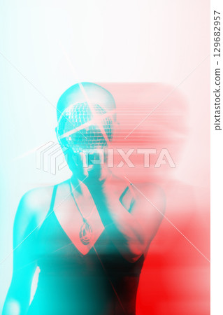 Woman with shaved head holding shining disco ball in RGB color split effect 129682957