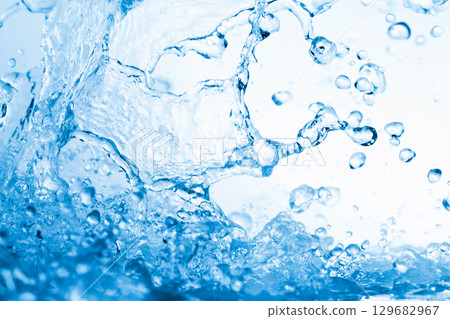 水濺在藍色背景上。 水濺在藍色背景上。 129682967
