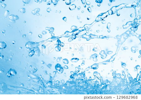 水濺在藍色背景上。 129682968