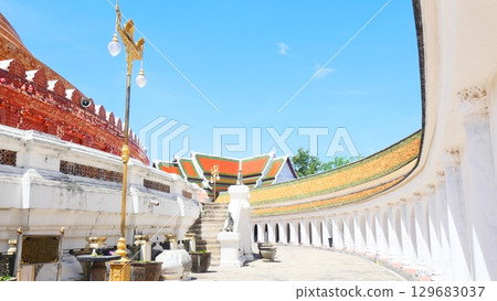 Beautiful arched walkway and traditional temple roof at a Buddhist temple in Thailand 129683037