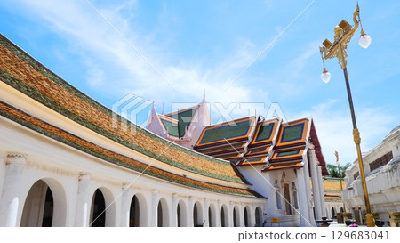 Beautiful temple architecture with arched walkway and traditional tiled roof in Thailand Beautiful temple architecture with arched walkway and traditional tiled roof in Thailand 129683041