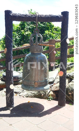 Large traditional bell hanging in a Buddhist temple in Thailand, used for religious ceremonies and spiritual practice Large traditional bell hanging in a Buddhist temple in Thailand, used for religious ceremonies and spiritual practice 129683043