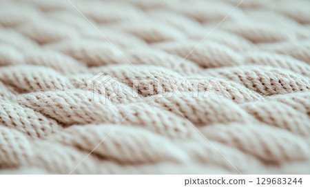 Abstract background Close up of woven fabric showcasing intricate patterns and textures, highlighting craftsmanship and detail in design. soft, natural tones create warm and inviting feel 129683244