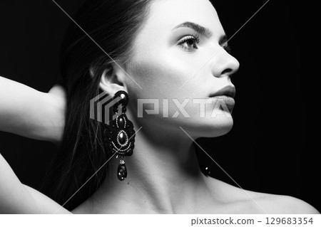Beautiful woman with fancy earrings studio portrait Beautiful woman with fancy earrings studio portrait 129683354