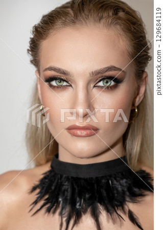 Beautiful woman with smokey makeup close up studio portrait Beautiful woman with smokey makeup close up studio portrait 129684119