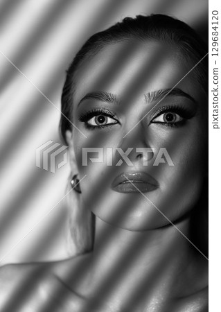Beautiful woman with smokey makeup close up studio portrait 129684120