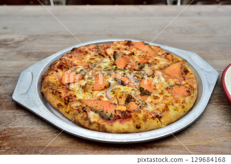 Gourmet salmon pizza on a metal tray Gourmet salmon pizza on a metal tray 129684168