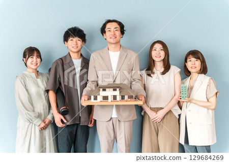 房屋製造商、設計辦公室或建築公司的男女員工拿著建築模型或房屋模型 房屋製造商、設計辦公室或建築公司的男女員工拿著建築模型或房屋模型 129684269