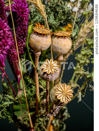 Dried Flower Bouquet and Wheat Stalks on Dark Backdrop 129684686