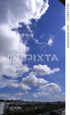 A dynamic summer sky spreads over the city of Okinawa 129685144