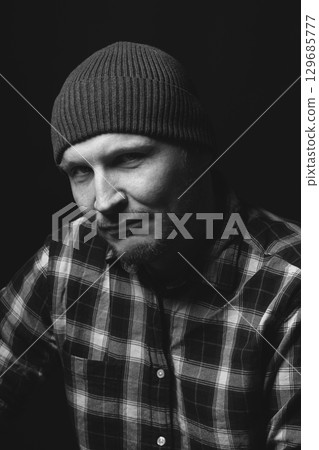Man with winter hat and checkered shirt studio portrait 129685777