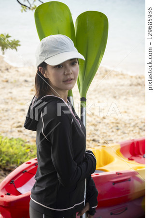 Cute woman enjoying kayaking Cute woman enjoying kayaking 129685936